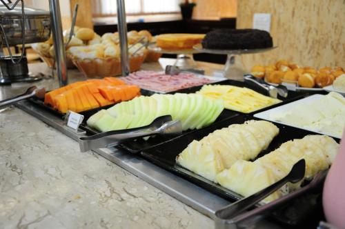 a buffet with many different types of cheese and vegetables at Brasília Santana Gold Flat in Sao Paulo