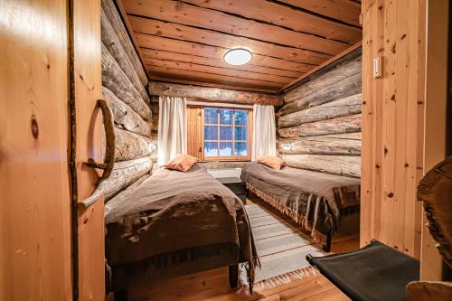 ein Schlafzimmer mit zwei Betten in einer Blockhütte in der Unterkunft Charming Cottage Levi in Levi