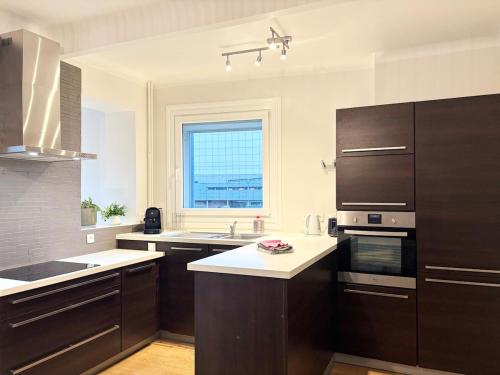 une grande cuisine avec des placards bruns et une fenêtre dans l'établissement Magnifique maison prox Lille - 4chb 2sdb, à Lambersart