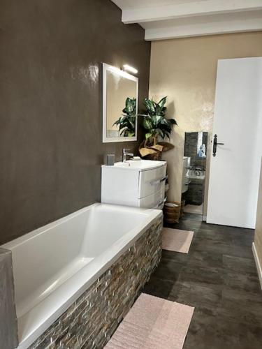 La salle de bains est pourvue d'une grande baignoire et d'un lavabo. dans l'établissement Maison de Village, à Gémenos