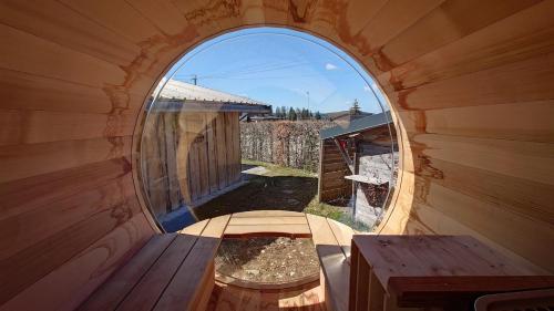 a small room with a round window and a table at Les pagotins de Garance, Chalet Jura 39, avec sauna panoramique in Métabief