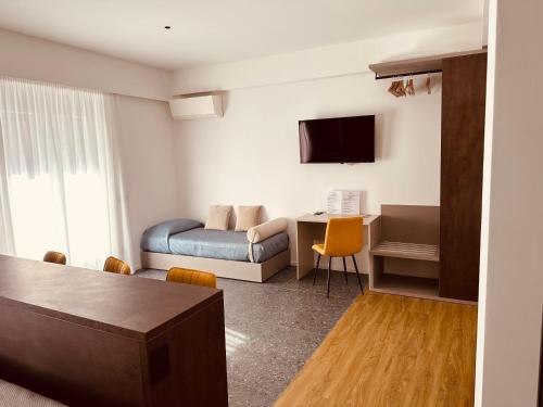 a room with a bed and a desk and a tv at Elegance Rooms Cefalù in Cefalù