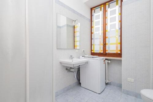 a white bathroom with a sink and a mirror at Duomo di Pavia - Comodo bilocale in centro città in Pavia