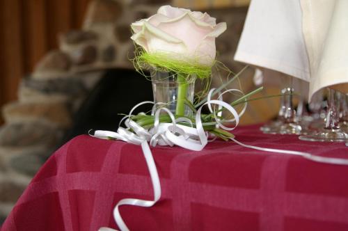 a vase with a white rose on a table at Waide Motel in Elva