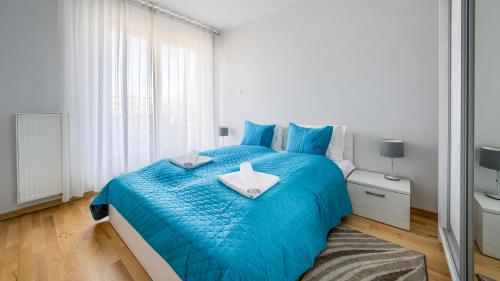 a bedroom with a blue bed and a window at Casa Marina, Sun & Snow in Świnoujście