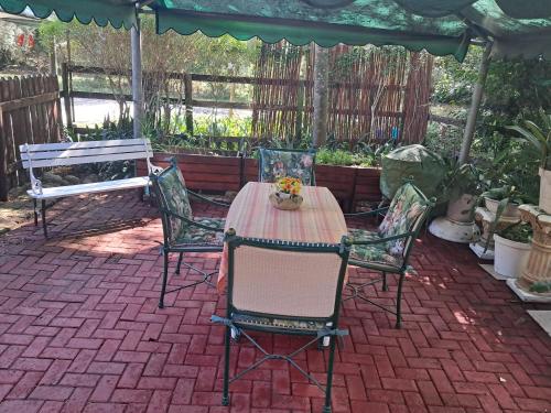 a table and chairs sitting on a brick patio at Glen House in Brenton-on-Sea