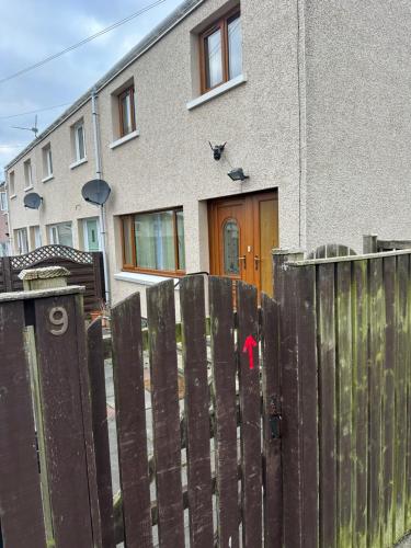 a wooden fence in front of a house at Modern & Cosy 3 Bedroom Inverkeithing home- Ideal for Edinburgh Dunfermline & St Andrews with Free Parking in Inverkeithing