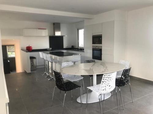 une cuisine avec une table et des chaises dans une pièce dans l'établissement Les tourterelles 3019, aux Issambres