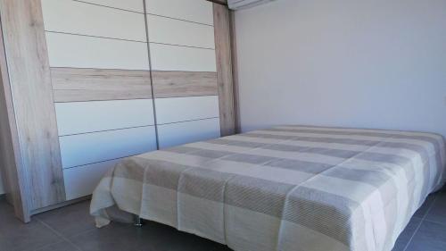 une chambre avec un lit avec une couverture à carreaux dans l'établissement Les tourterelles 3019, aux Issambres
