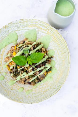 a plate of food with a salad and a bowl of sauce at Surf Yoga Ericeira Guest House in Ericeira