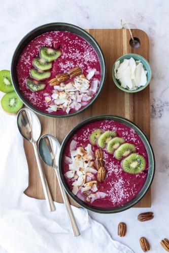 two bowls of food sitting on a wooden cutting board at Surf Yoga Ericeira Guest House in Ericeira