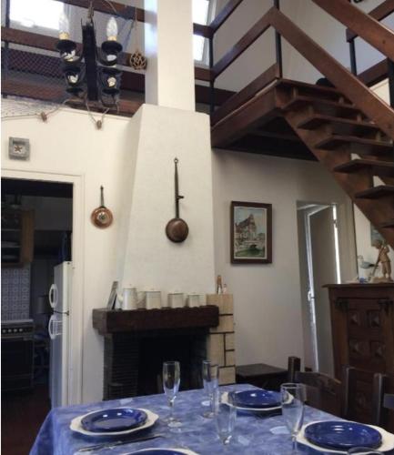 une table avec une nappe bleue et une cheminée dans l'établissement Maison bord de mer la Turballe, à La Turballe