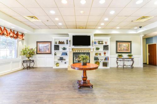 a large room with a table and a tv in it at OYO Townhouse Oklahoma City Airport in Oklahoma City