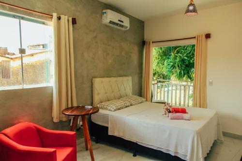 a bedroom with a bed and a chair and a window at Go Pipa INN in Pipa