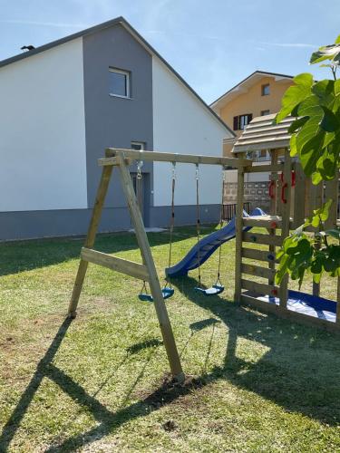 a swing set in a yard with a house at AusZeit Neusiedlersee in Mörbisch am See