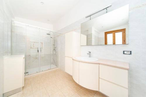 a white bathroom with a sink and a shower at Giulio in Campagnano di Roma