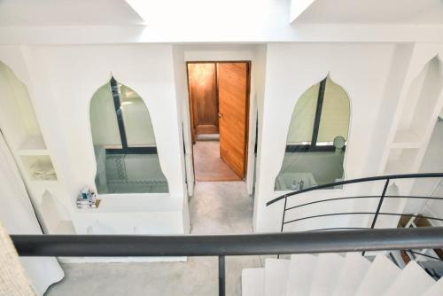 Un escalier avec deux miroirs et une porte en bois dans l'établissement Les Nymphéas, peaceful haven & private pond, à Angresse