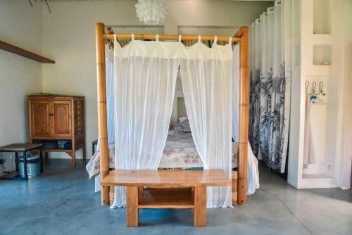 Cette chambre comprend un lit à baldaquin en bois. dans l'établissement Les Nymphéas, peaceful haven & private pond, à Angresse