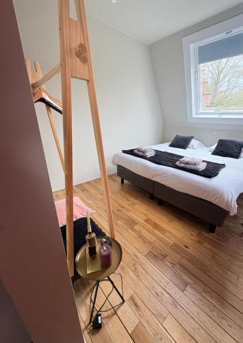a bedroom with a bed and a wooden floor at Ryckevelde in Damme