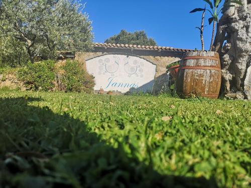 a sign that says jamaica with a barrel in the grass at Affittcamere Jannas in Orgosolo