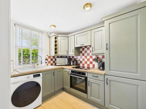 a kitchen with white cabinets and a dishwasher at Cosy Chester Cottage - Quaint Stay Sleeps 2-5 in Chester