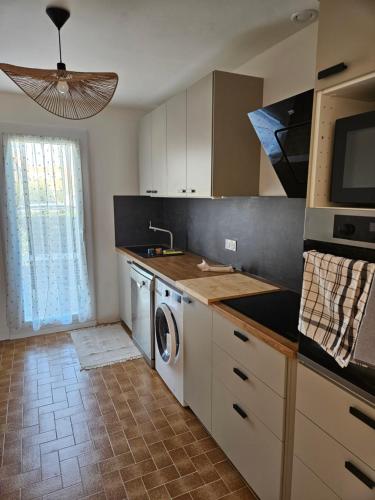Il comprend une cuisine équipée d'un lave-linge, d'un évier et d'un lave-vaisselle. dans l'établissement Maison de vacances avec jardin à 500 m de la plage, à Valras-Plage