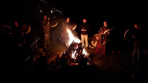 a group of people standing around a bonfire at night at Sacred Valley Mystic Tribe - Community Life in Pisac