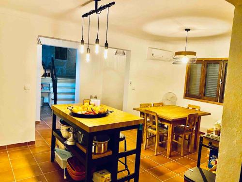 a kitchen with a table with a bowl of fruit on it at My Grandmas School in São João de Areias