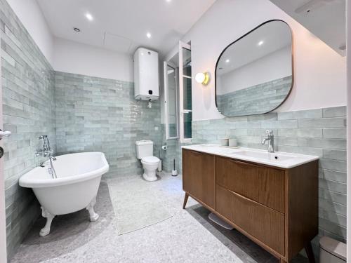 une salle de bain avec une baignoire, un lavabo et un miroir dans l'établissement ApartHotel Riviera - Le Balcon du GRAND ALEXANDRE - Amazing 3 berdooms - Old Town Promenade des Anglais, à Nice