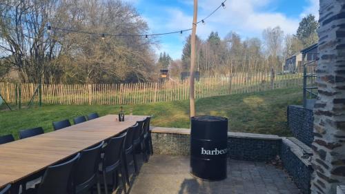 a long table with blue chairs and a trash can at Eduard - Gîte Ardennais in Houffalize