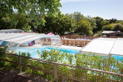 une piscine avec un auvent et une clôture dans l'établissement Camping Le Paradis - Maeva, à Talmont-Saint-Hilaire