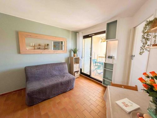 un salon avec une chaise et une table dans l'établissement T2 au calme avec piscine et parking, à Six-Fours-les-Plages