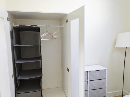 a closet with black shelves and a white wall at Room bhm city centre in Birmingham