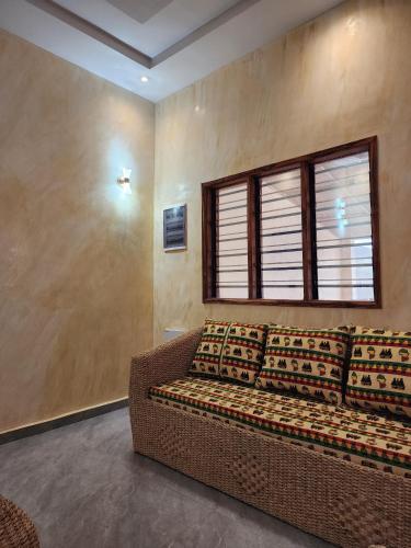 a couch in a room with a window at Maison Porto-novo in Aboga