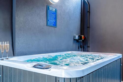a bath tub with blue water in a room at Stylish Stokes Croft Apartment, private hot tub in Bristol