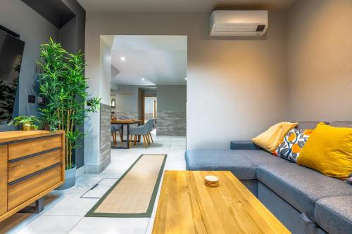 a living room with a blue couch and a wooden table at Stylish Stokes Croft Apartment, private hot tub in Bristol