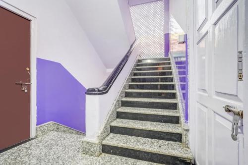 a staircase in a building with purple walls at Super Hotel O Pradhan Nagar Siliguri Formerly Prince Guest House in Siliguri