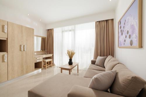 a living room with a couch and a table at Mythos Panorama - Adults Only in Boukari