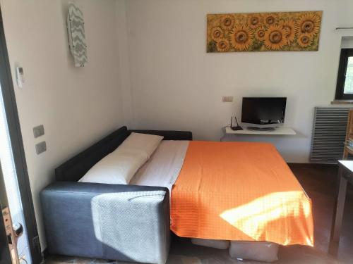 Capraia e LimiteにあるCasa Margheritaのオレンジ色の毛布が掛けられたベッドのある寝室