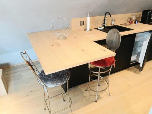 - une cuisine avec un comptoir, un évier et 2 chaises dans l'établissement L'Ecrin de Velours Elégant-Paisible, à Rosheim