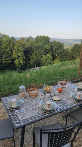 - une table de pique-nique avec de la nourriture et des paniers dans l'établissement La Parenthèse - Gîte de la Sittelle, à Saint-Genix-sur-Guiers