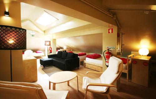 a living room with a couch and a table and chairs at PILOT Design Hostel & Bar in Porto