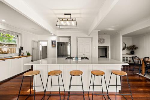 a kitchen with a counter with stools and a island at Bells Beach Bungalow in Clontarf