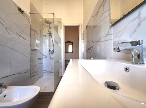 a white bathroom with a sink and a shower at Villa Charlene in Terrauzza
