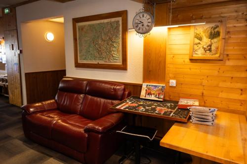 a leather couch sitting in a room with a table at Hotel l'Aigle in Valmeinier
