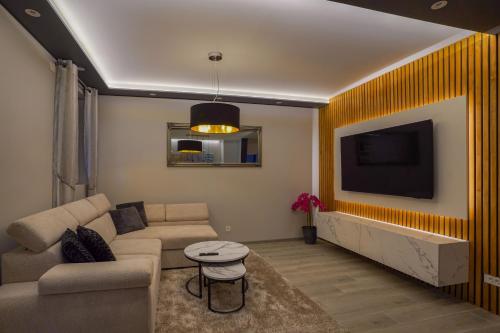 a living room with a couch and a flat screen tv at Franjković Premium Suite with Private Jacuzzi & Sauna in Seliste Dreznicko