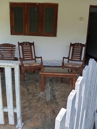 two chairs and a wooden table in a room at Sunshine Cafe in Tangalle