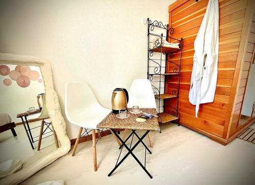 - une chambre avec une table, deux chaises et une porte dans l'établissement La Villa Scarlett, à Paluel