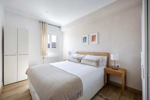a white bedroom with a bed and a window at Amazing 3bdr Apt In Cornella 1 Mins From Metro in Cornellà de Llobregat