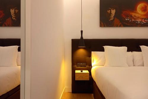 a bedroom with two beds and a pendant light at Woohoo Rooms Unique Madrid in Madrid